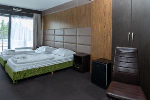 a bedroom with a large bed and a chair at Panorama in Okuninka