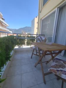 a wooden picnic table on a balcony with a view at Filikon maisonettes in Kalamata