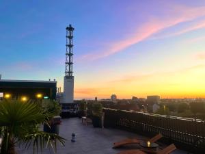 a balcony with a view of the city at sunset at Twins Hotel in Duisburg +10 photos