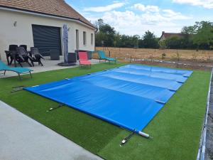 a large blue trampoline on the grass at le pavillon in Bonnat
