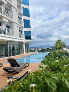 a building with a swimming pool and a chair at Condo Inspiria Beside Abreeza Mall in Davao City