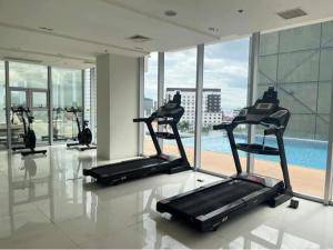 a gym with cardio machines in a building with a pool at Condo Inspiria Beside Abreeza Mall in Davao City