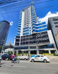 a large building with cars parked in front of it at Condo Inspiria Beside Abreeza Mall in Davao City