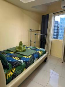 a bedroom with a bed with a hat on it at Shell Residences MOA&NAIA by-Sandy in Manila +13 photos