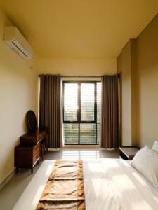 a bedroom with a bed and a desk and a window at Apatto Bajo in Labuan Bajo