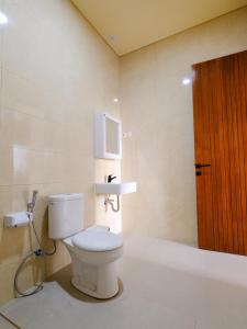 a bathroom with a toilet and a sink at Apatto Bajo in Labuan Bajo +39 photos