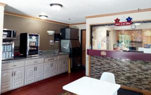 a restaurant kitchen with a counter and a refrigerator at Super 8 by Wyndham Dunbar/Charleston Area in Charleston +17 photos
