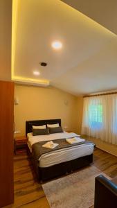 a bedroom with a large bed and a window at Badul Pansiyon in Uzungöl