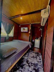 a small bedroom with a bed and a tv in it at Lamai Home 2 in Ko Yao Noi
