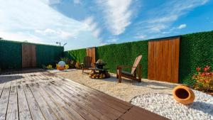 a backyard with a wooden deck with a green hedge at JUNGLOW Sapanca in Sapanca