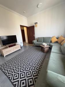 a living room with a couch and a flat screen tv at أوريانا oRIANA in Jeddah