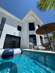 a villa with a swimming pool in front of a house at Sea 300 Villa in Migdal