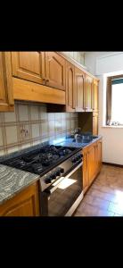 a kitchen with wooden cabinets and a stove top oven at Casa Vacanze Alba in Pianillo