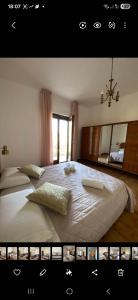 a bedroom with a large white bed with a chandelier at Casa Vacanze Alba in Pianillo