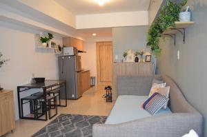 a living room with a couch and a kitchen at Condo Inspiria Beside Abreeza Mall in Davao City