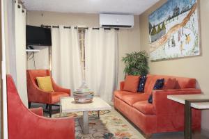 a living room with a couch and two chairs at The Stafford Lodge in Freetown