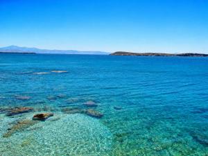 a large body of blue water with rocks at Blue Sea Paros Aegean Horizon in Drios