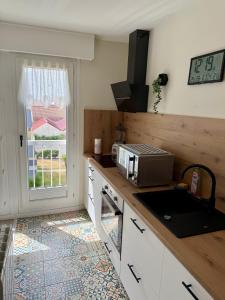 a kitchen with a counter with a microwave and a window at Escale Berckoise Studio Cosy Proche des Phoques in Berck-sur-Mer