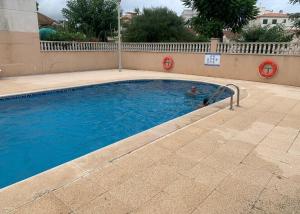 a swimming pool with a person in the water at Casa de playa in Roda de Bará