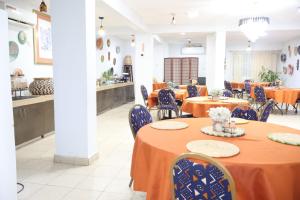 a dining room with tables and chairs and a kitchen at The Stafford Lodge in Freetown