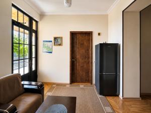 a living room with a refrigerator and a couch at Guest House Gardenia & Wine Cellar in Lagodekhi