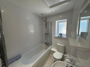 a white bathroom with a toilet and a sink at Little Newlyn in Newlyn