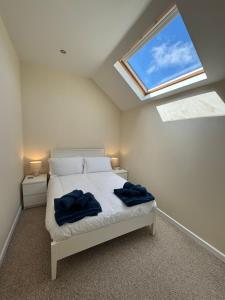 a bedroom with a bed with two blue towels on it at Little Newlyn in Newlyn +4 photos