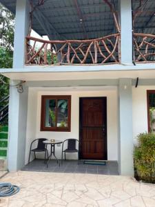 a house with a table and chairs in front of a door at BalikBalik Villa in El Nido