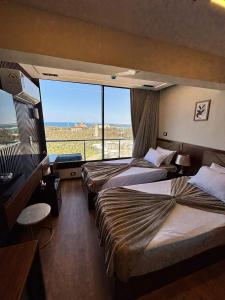 a hotel room with two beds and a large window at Montaza City in Alexandria