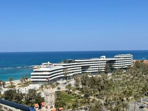 a large building on the beach with the ocean at Montaza City in Alexandria