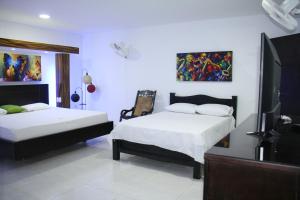 Postel nebo postele na pokoji v ubytování Hotel El Bosque Valledupar