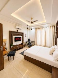 a bedroom with a king sized bed and a tv at Entire 3BHK Villa for Families & Groups with Kids Play Area in Jaipur