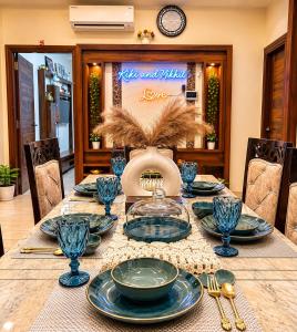 a dining room table with blue dishes on it at Entire 3BHK Villa for Families & Groups with Kids Play Area in Jaipur