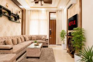 a living room with a couch and a tv at Entire 3BHK Villa for Families & Groups with Kids Play Area in Jaipur