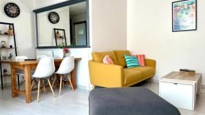 a living room with a yellow couch and a table at Un,Deux,Trois...Soleil in Le Pradet