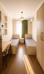 a room with two beds and a table and a window at Casa Camellia in Kobuleti