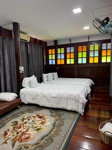 a bedroom with two beds and a rug at น่านสุขโข โฮมสเตย์ in Ban Na Tho