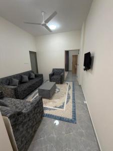a living room with couches and a flat screen tv at حياة صحلنوت in Salalah