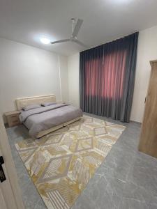 a bedroom with a bed and a rug on the floor at حياة صحلنوت in Salalah