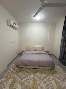a bedroom with a bed with a rug on the floor at حياة صحلنوت in Salalah