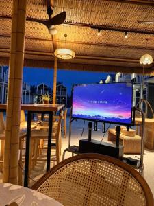 a large screen tv on a balcony with a table at All Season Resort Semporna in Semporna