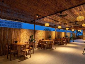 a restaurant with wooden tables and chairs and lights at All Season Resort Semporna in Semporna