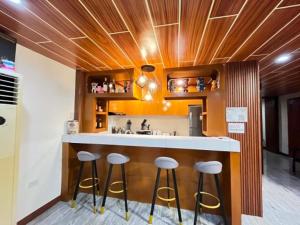 a kitchen with stools at a counter with a sink at BalikBalik Villa in El Nido