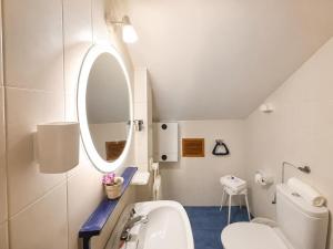 ein Badezimmer mit weißer Toilette und Spiegel in der Unterkunft Holibai Mar de Lua, Vila gallega al lado del mar cerca de Baiona in Oia + 35 Fotos
