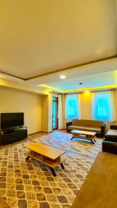 a large living room with couches and a flat screen tv at Badul Pansiyon in Uzungöl