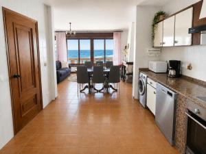 eine Küche und ein Esszimmer mit Tisch und Stühlen in der Unterkunft Holibai Mar de Lua, Vila gallega al lado del mar cerca de Baiona in Oia