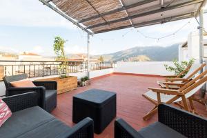a patio with chairs and tables on a roof at Patio Morisco - WIFI - free parking in Órgiva