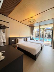 a hotel room with two beds and a desk and a table at All Season Resort Semporna in Semporna +21 photos