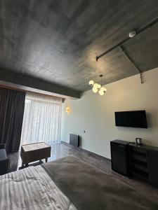 a bedroom with a bed and a desk and a television at Royal Forest Dilijan in Dilijan