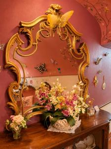 a mirror sitting on top of a table with flowers at La Rocca Sospesa - Castello in Apricale